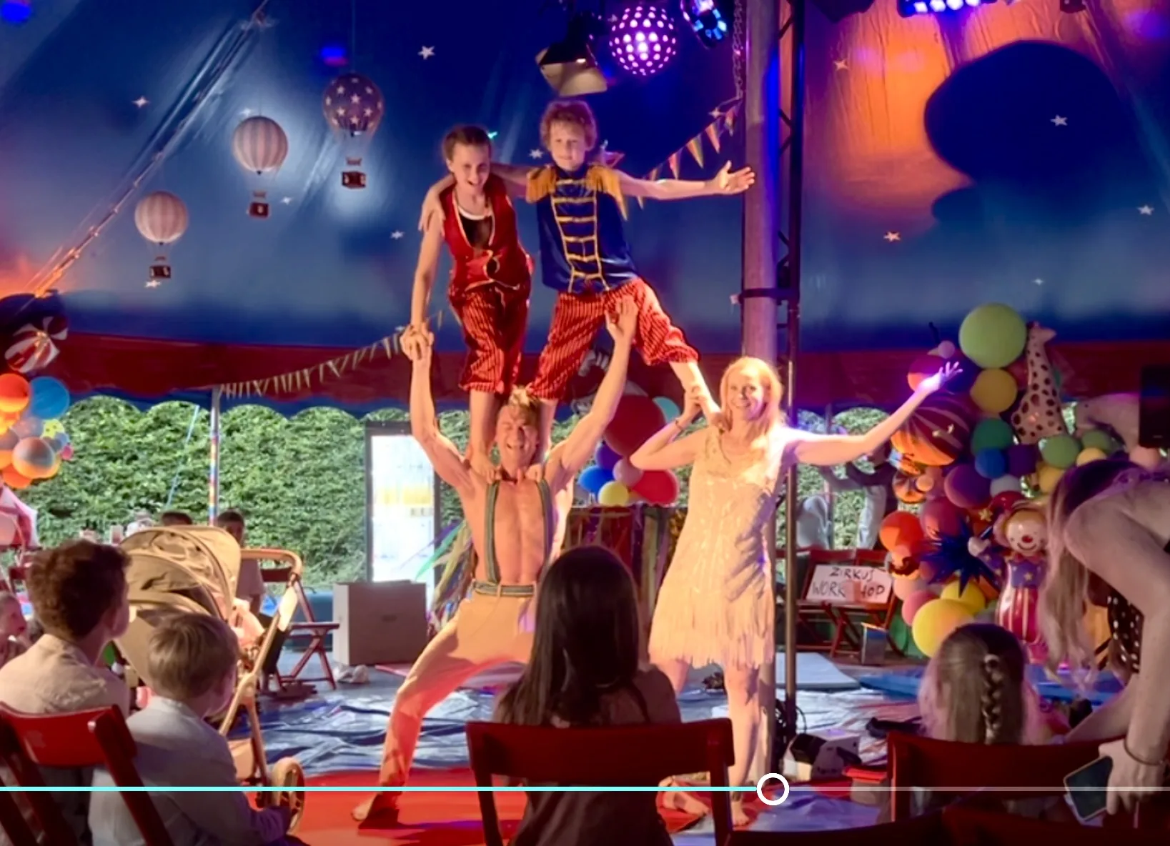 Hands-on human pyramid with kids and family cast in the circus tent
