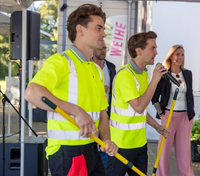 Jim and John hosting a summer party, one with a microphone in hand